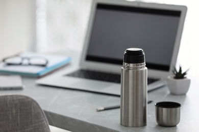 Thermo bottle on table in modern office