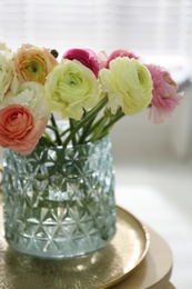 Beautiful ranunculus flowers in vase on table indoors, closeup