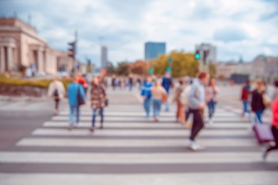 People crossing street in city, blurred view