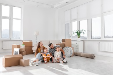 Happy family sitting on floor in new apartment. Moving day