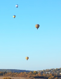Colorful hot air balloons flying over countryside