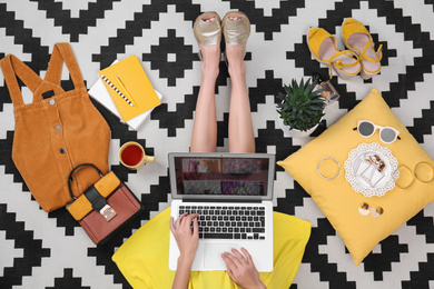Fashion blogger with laptop sitting on floor, top view