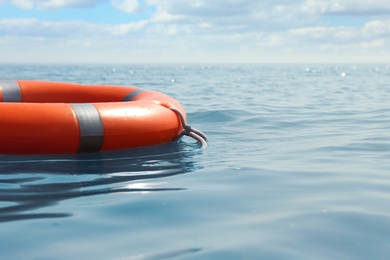 Orange life buoy floating in sea. Emergency rescue equipment