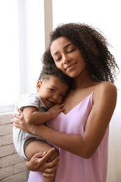 African-American woman with her baby at home. Happiness of motherhood