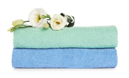 Folded clean soft towels with flowers isolated on white