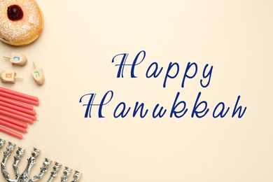 Happy Hanukkah. Traditional menorah, candles, sufganiyah and dreidels on beige background, flat lay 