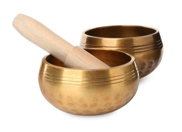Golden singing bowls with mallet on white background. Sound healing