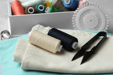 Photo of Spools of threads and sewing tools on table