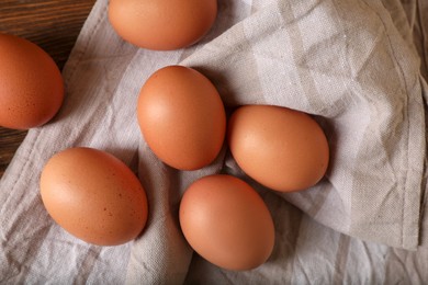 Photo of Raw brown chicken eggs on wooden table, flat lay