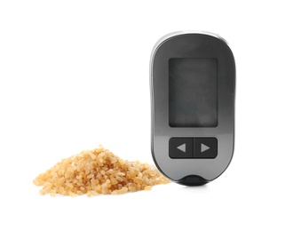 Digital glucometer and brown sugar on white background. Diabetes concept
