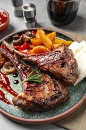 Photo of Delicious grilled ribs served on grey table