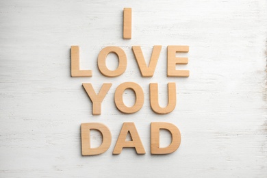 Words I LOVE YOU DAD with wooden letters on white table, flat lay
