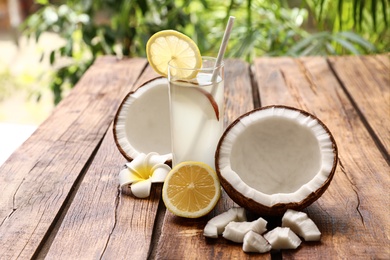Composition with glass of coconut water and lemon on wooden table