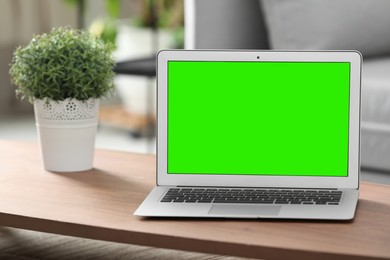 Image of Laptop display with chroma key on desk in room