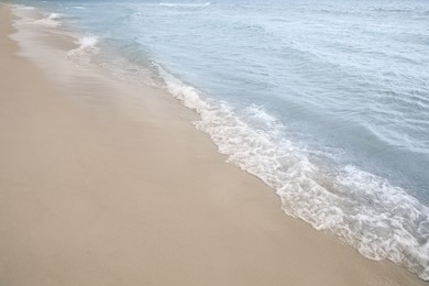 Sea waves rolling onto sandy tropical beach