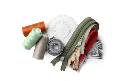 Spools of threads and sewing tools on white background, top view