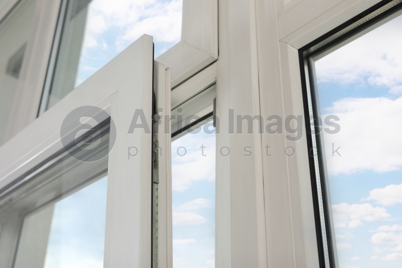 Open window with white plastic frame indoors, low angle view