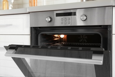 Photo of Open modern oven built in kitchen furniture, closeup