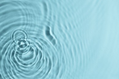 Closeup view of water with circles on turquoise background. Space for text