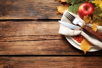 Festive table setting on wooden background, above view with space for text. Thanksgiving Day celebration