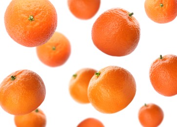 Fresh ripe tangerines falling on white background