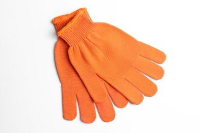 Photo of Orange gardening gloves on white background, top view