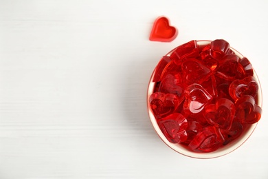 Tasty heart shaped jelly candies on white table, flat lay. Space for text