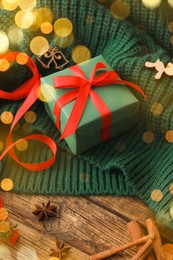 Photo of Christmas gift box and decor on wooden table, closeup