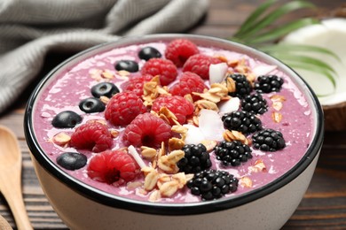 Photo of Delicious acai smoothie with berries and oatmeal on table, closeup
