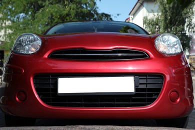 Red car with vehicle registration plate outdoors