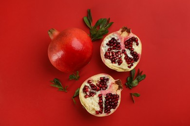 Flat lay composition with ripe pomegranates on red background