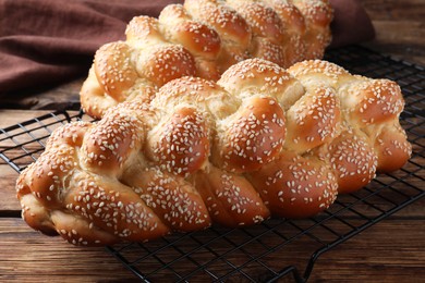 Homemade braided breads with sesame seeds on wooden table, closeup. Challah for Shabbat