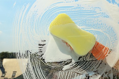 Photo of Person cleaning glass with sponge, view from inside