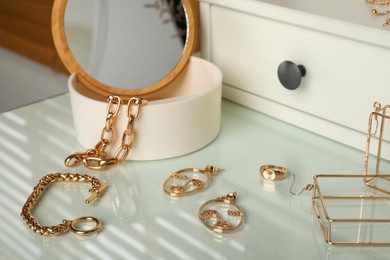 Jewelry box with mirror and stylish golden bijouterie on white dressing table