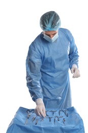 Doctor taking surgical instrument from table on light background