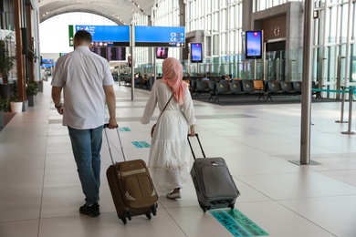 ISTANBUL, TURKEY - AUGUST 13, 2019: Couple with suitcases in new airport terminal