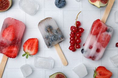 Flat lay composition with berry ice pops on light table