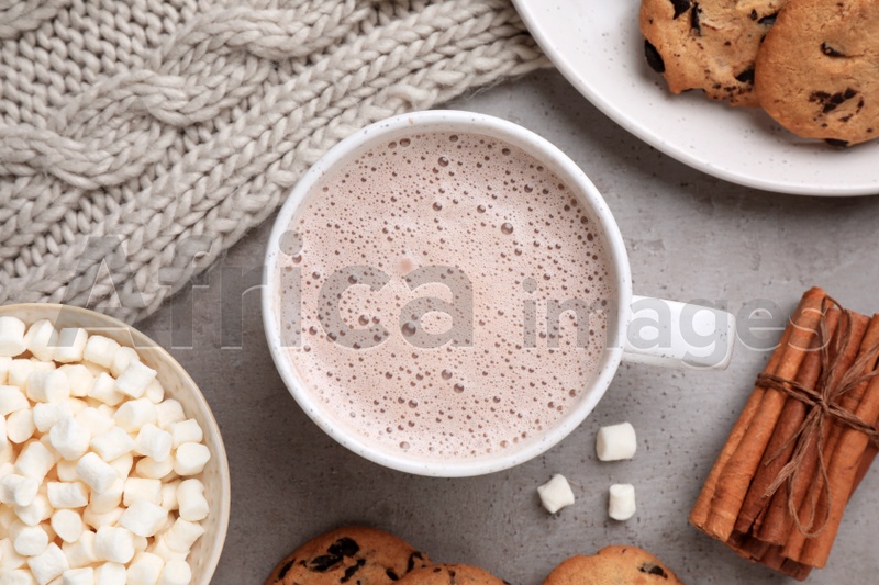 Flat lay composition with cup of delicious hot cocoa on grey table