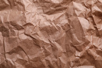 Texture of wrinkled kraft paper bag as background, closeup