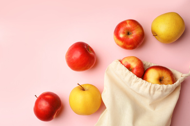 Cotton eco bag and apples on pink background, flat lay