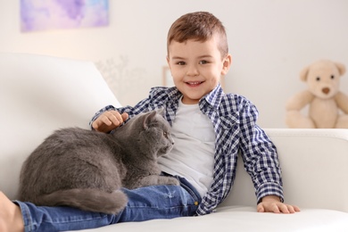 Photo of Cute little child with cat at home