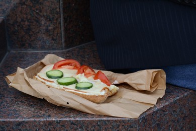 Photo of Tasty sandwich with vegetables on stone surface outdoors. Street food