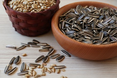 Photo of Organic sunflower seeds on white wooden table, closeup