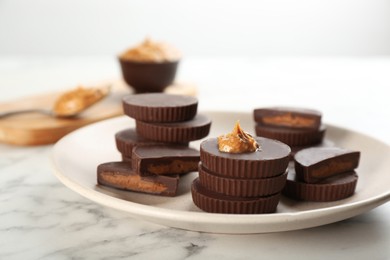 Photo of Delicious peanut butter cups on white marble table