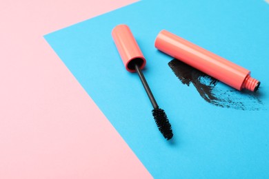 Mascara and smear on color background, space for text. Makeup product