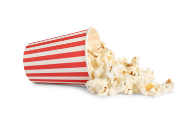 Overturned paper cup with delicious popcorn isolated on white