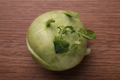 Whole ripe kohlrabi plant on wooden table, top view