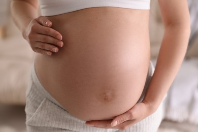 Young pregnant woman on blurred background, closeup view