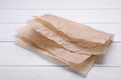 Photo of Sheets of baking paper on white wooden table
