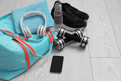 Sports bag and gym stuff on wooden floor
